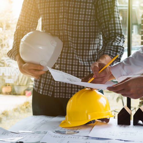 Hard hat with people reviewing plans